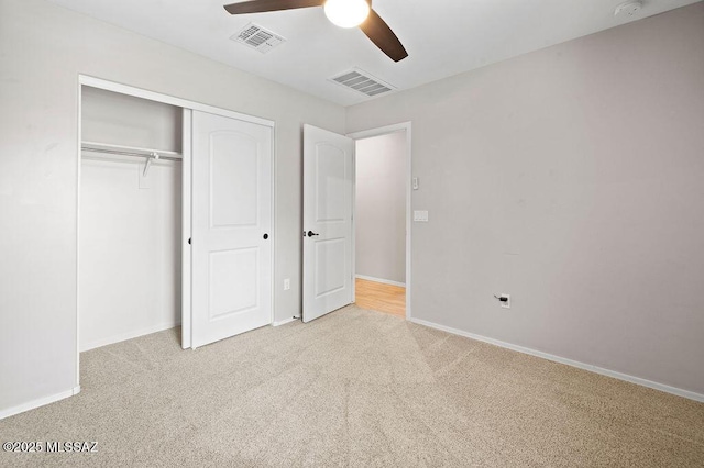 unfurnished bedroom with light carpet, a closet, and ceiling fan