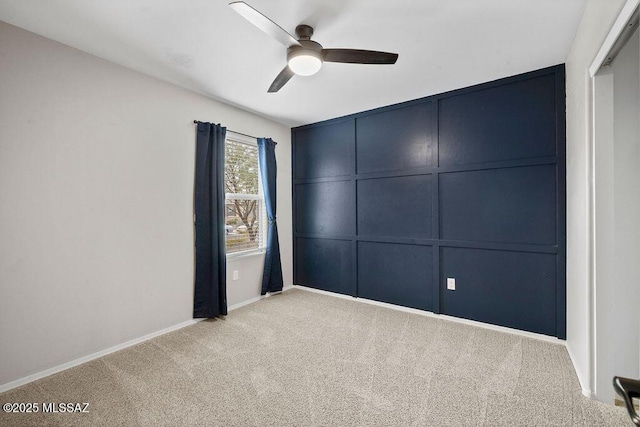 spare room featuring light colored carpet and ceiling fan