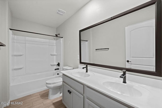 full bathroom with wood-type flooring, toilet, vanity, and  shower combination