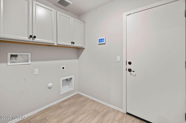 clothes washing area featuring electric dryer hookup, hookup for a washing machine, cabinets, hookup for a gas dryer, and light wood-type flooring