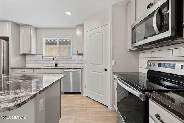 kitchen featuring stainless steel appliances, tasteful backsplash, sink, and white cabinets