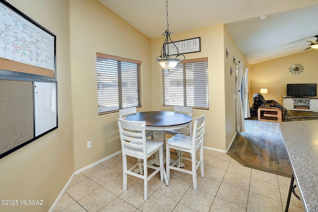 dining room with light tile patterned floors, vaulted ceiling, and ceiling fan