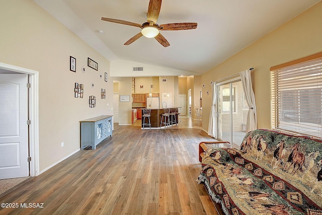 living room with lofted ceiling, hardwood / wood-style floors, and ceiling fan