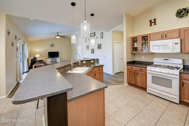 kitchen with decorative light fixtures, an island with sink, lofted ceiling, sink, and white appliances