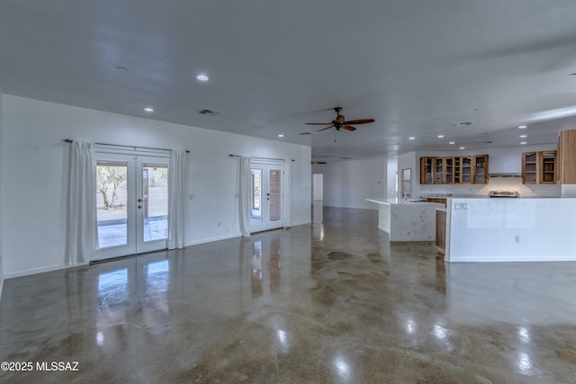 unfurnished living room featuring french doors and ceiling fan