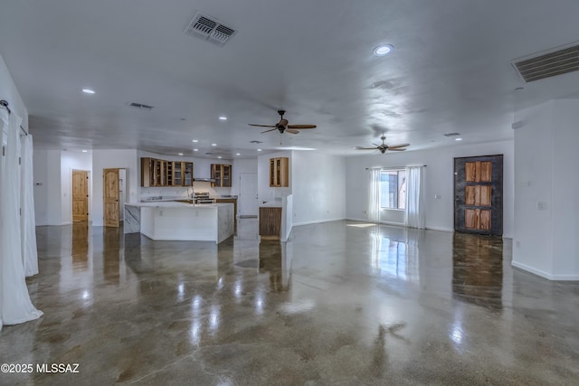 unfurnished living room with sink and ceiling fan