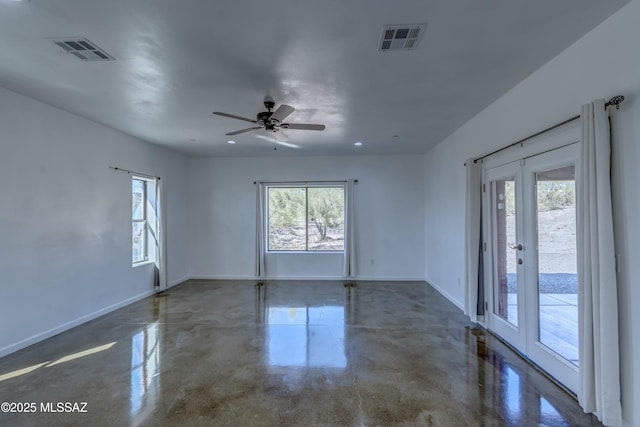 empty room with plenty of natural light, french doors, and ceiling fan