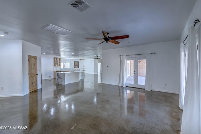 unfurnished living room with french doors, ceiling fan, and sink