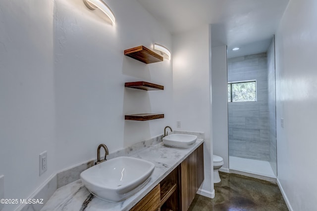 bathroom featuring concrete flooring, vanity, tiled shower, and toilet