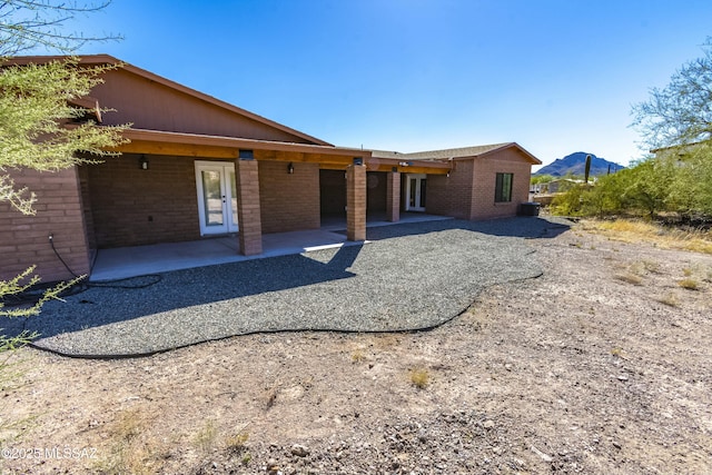 rear view of house with a patio and a mountain view