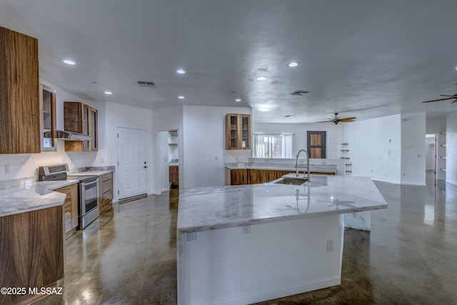 kitchen featuring sink, stainless steel range with electric cooktop, a large island, ceiling fan, and light stone countertops