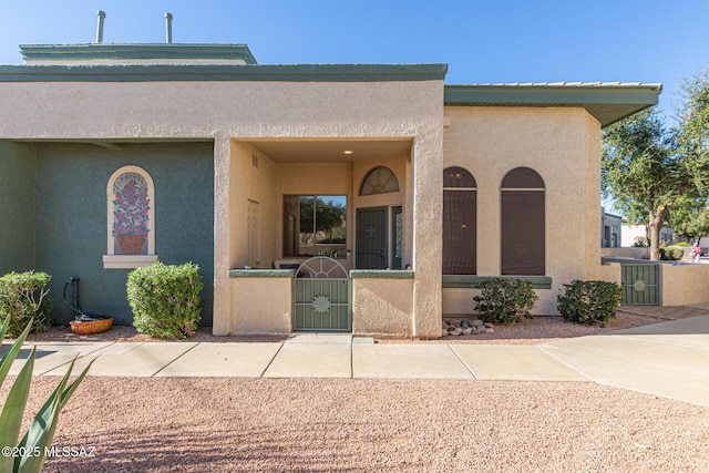 view of front of home featuring a fenced front yard, a gate, and stucco siding