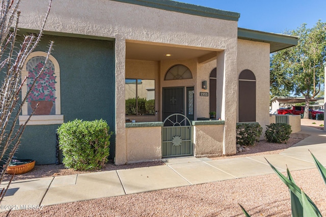 entrance to property with a gate and stucco siding