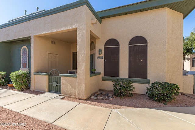 view of front of property featuring a fenced front yard, a gate, and stucco siding