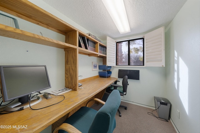 office space with light carpet, built in desk, and a textured ceiling