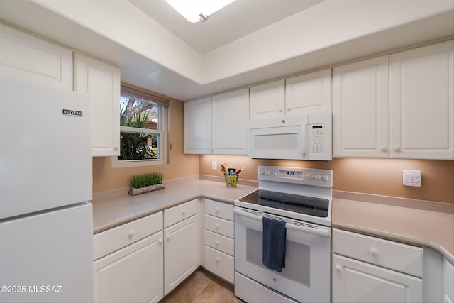 kitchen with light countertops, white appliances, and white cabinetry