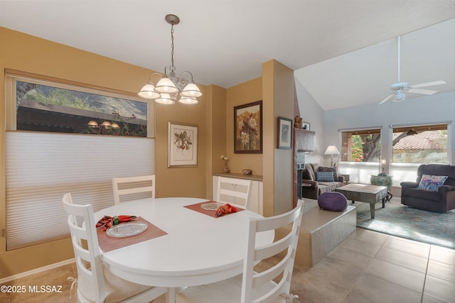 dining room with lofted ceiling, light tile patterned floors, and ceiling fan with notable chandelier