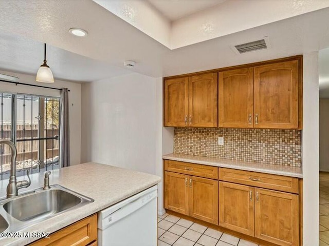 kitchen with sink, tasteful backsplash, decorative light fixtures, light tile patterned floors, and white dishwasher