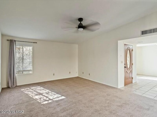 carpeted spare room with ceiling fan and vaulted ceiling