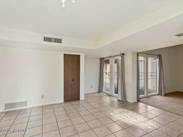 spare room featuring light tile patterned floors and a tray ceiling