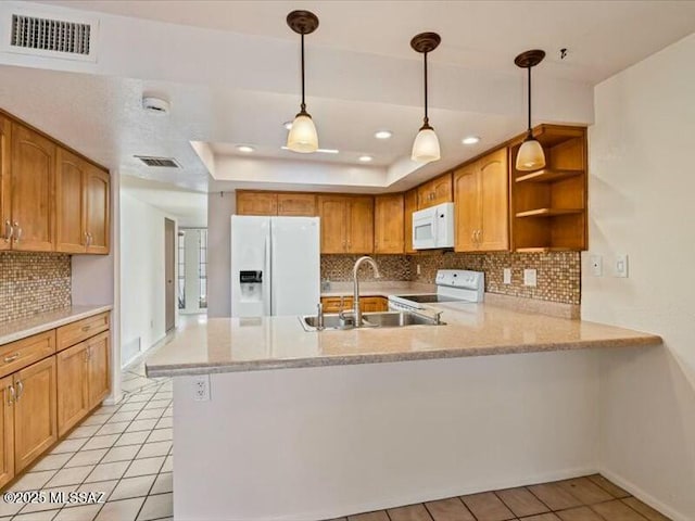 kitchen featuring white appliances, a tray ceiling, kitchen peninsula, and sink