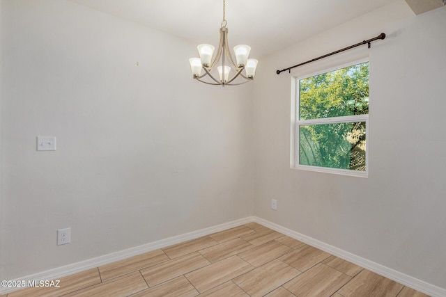 unfurnished room featuring an inviting chandelier