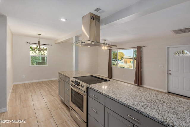 kitchen featuring gray cabinetry, hanging light fixtures, island exhaust hood, light stone counters, and stainless steel electric range