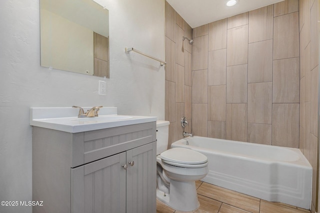 full bathroom featuring tiled shower / bath, vanity, and toilet