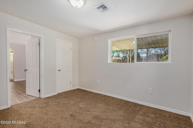 unfurnished bedroom with light carpet and a closet