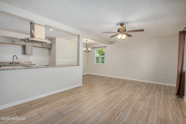 unfurnished living room with ceiling fan with notable chandelier