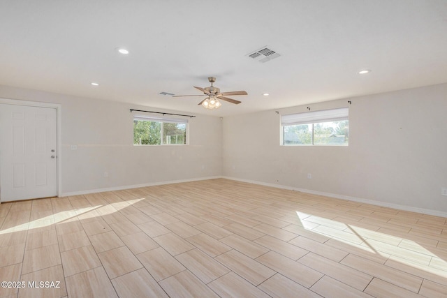 unfurnished room with ceiling fan and a healthy amount of sunlight