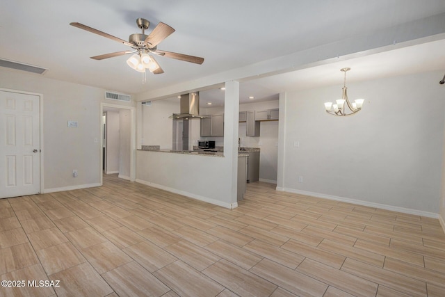 unfurnished living room featuring ceiling fan with notable chandelier