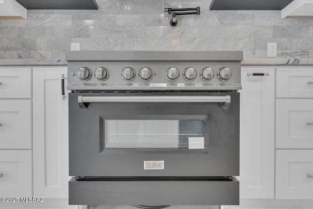 details featuring white cabinetry, stainless steel stove, and decorative backsplash