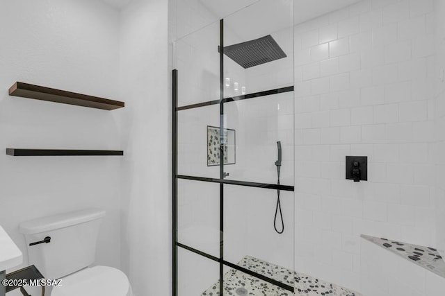 bathroom featuring toilet and a tile shower