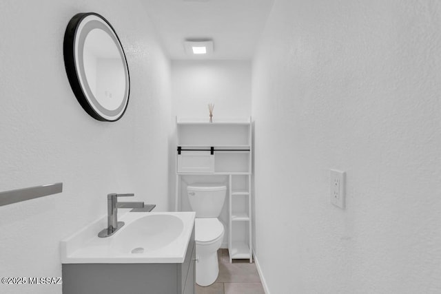 bathroom featuring vanity, tile patterned flooring, and toilet