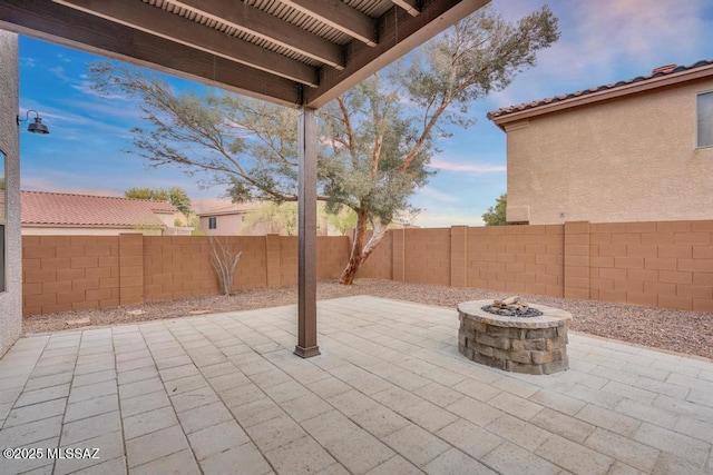 patio terrace at dusk featuring a fire pit