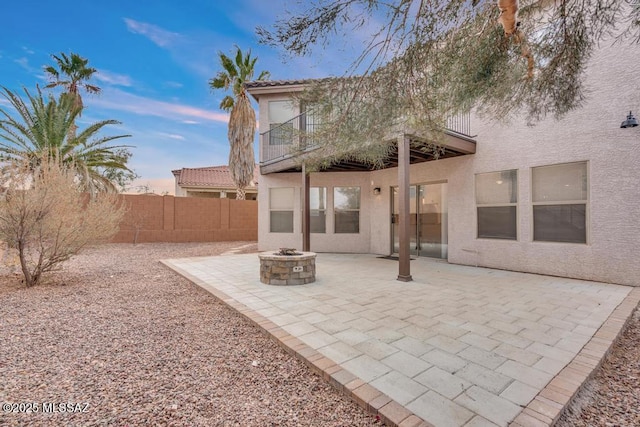 back house at dusk with an outdoor fire pit and a patio area