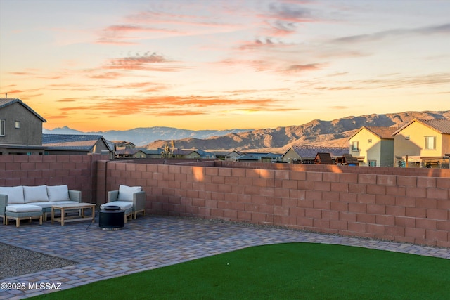 yard at dusk featuring outdoor lounge area, a mountain view, and a patio area