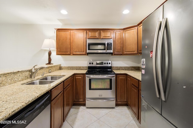 kitchen featuring sink, light tile patterned floors, stainless steel appliances, and light stone countertops