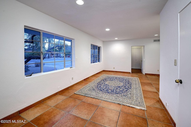 empty room featuring recessed lighting, visible vents, and baseboards