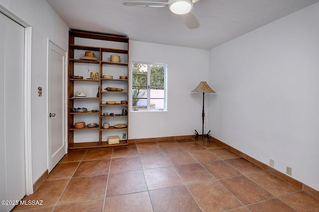 spare room featuring a ceiling fan, tile patterned flooring, and baseboards