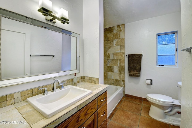 bathroom featuring tile patterned flooring, baseboards, vanity, and toilet