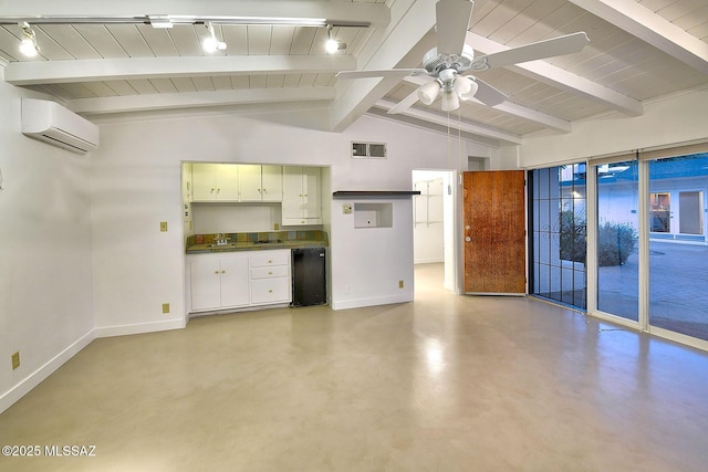 kitchen with finished concrete flooring, visible vents, baseboards, vaulted ceiling with beams, and an AC wall unit