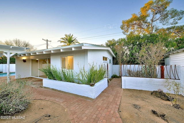 mid-century inspired home with a patio area and fence