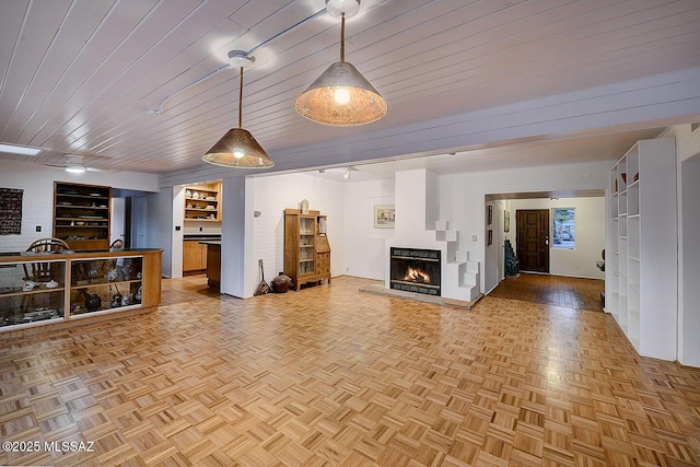 unfurnished living room with wood ceiling, a ceiling fan, and a multi sided fireplace