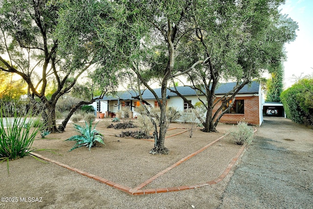 view of front facade with driveway and brick siding