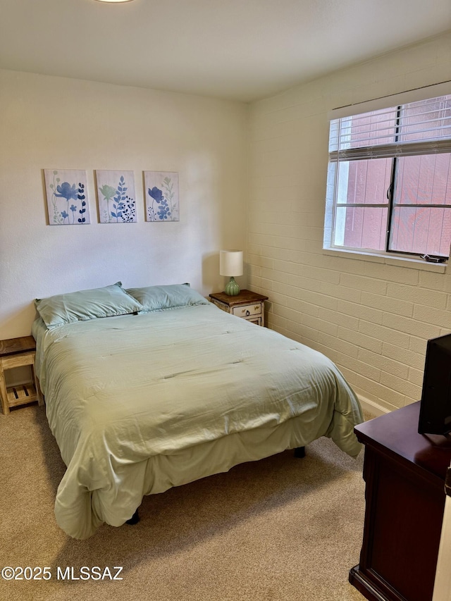 bedroom featuring brick wall and carpet floors