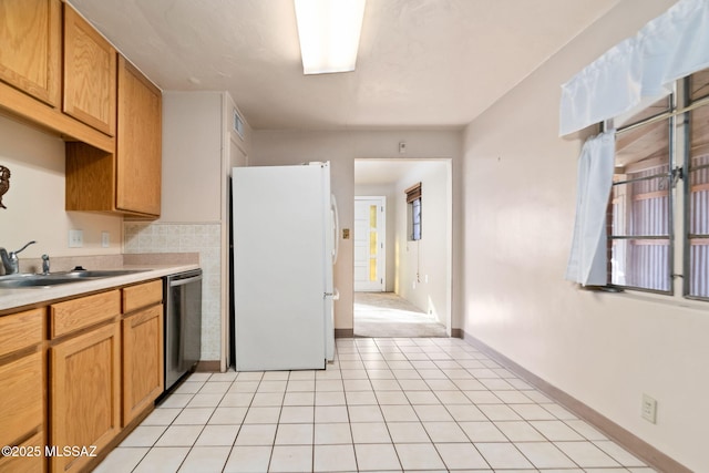 kitchen featuring dishwasher, white fridge, sink, and light tile patterned floors