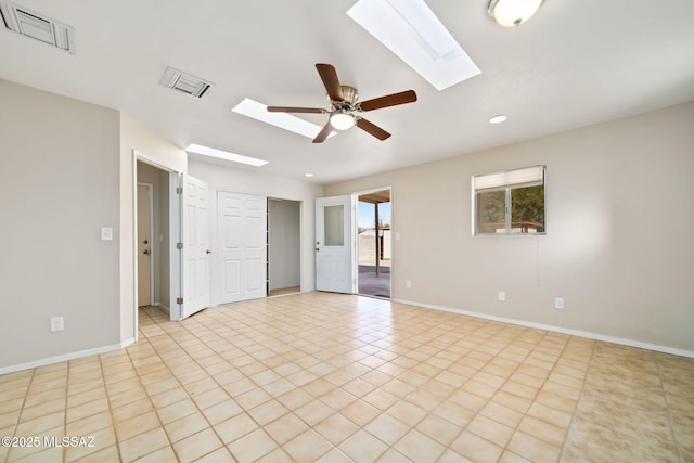 tiled spare room featuring a skylight and ceiling fan