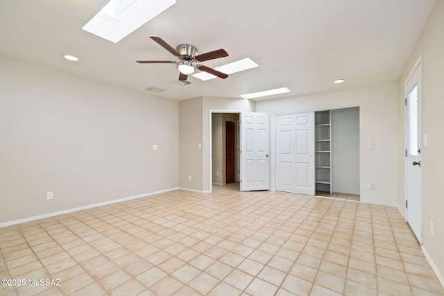 spare room featuring a skylight and ceiling fan